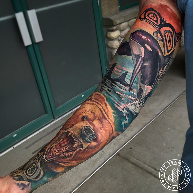 full wildlife arm sleeve tattoo with grizzly bear and orca